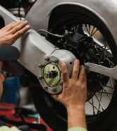 Repairman repair motorcycle, maintenance in garage. Mechanic fixing bike in a modern shop
