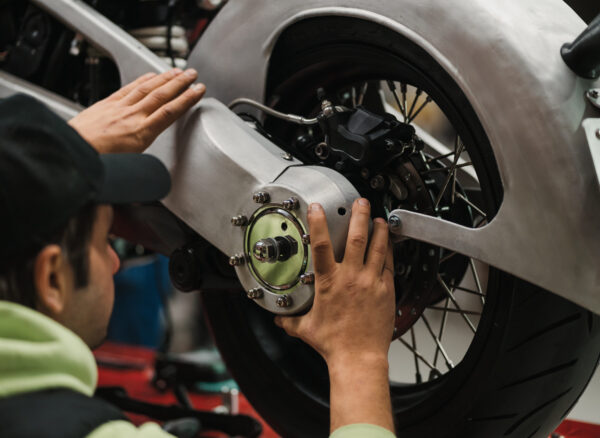 Repairman repair motorcycle, maintenance in garage. Mechanic fixing bike in a modern shop