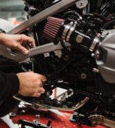 Repairman repair motorcycle, maintenance in garage. Mechanic fixing bike in a modern shop