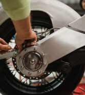 Repairman repair motorcycle, maintenance in garage. Mechanic fixing bike in a modern shop