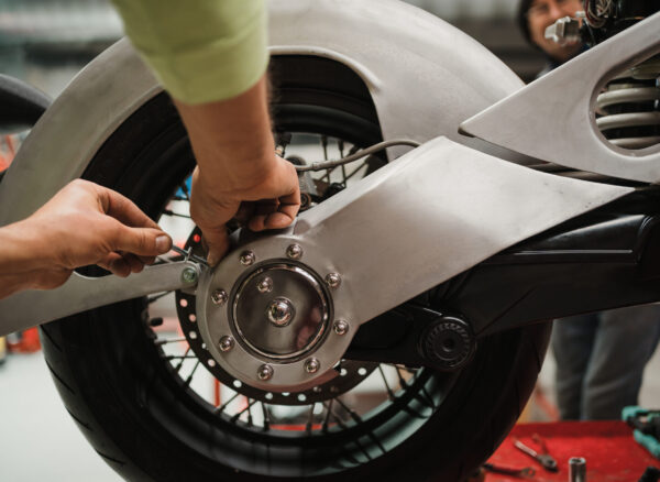 Repairman repair motorcycle, maintenance in garage. Mechanic fixing bike in a modern shop