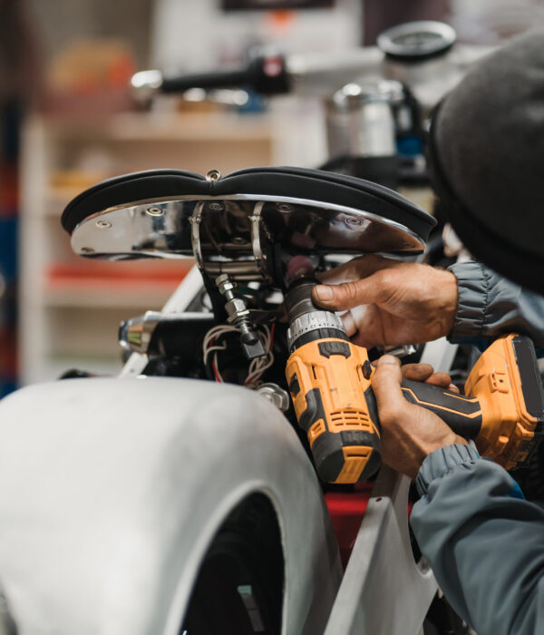 Repairman repair motorcycle, maintenance in garage. Mechanic fixing bike in a modern shop